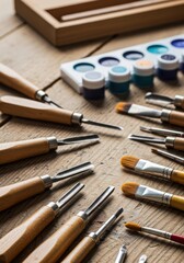 Fototapeta premium Wood Carving Tools and Watercolor Paints on Wooden Table