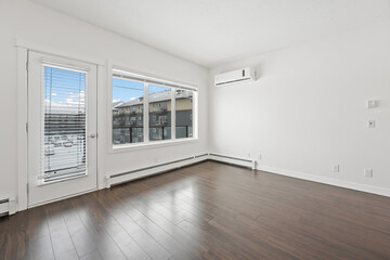 Large empty room with a window and a heater