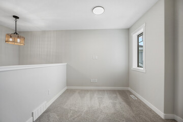 White room with a light fixture hanging from the ceiling
