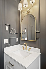 Bathroom with a white sink and a gold faucet