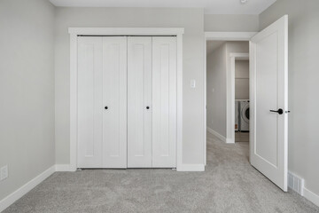White bedroom with a white door and white closet
