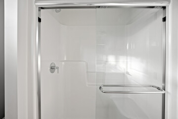 Clear shower stall with a silver handle