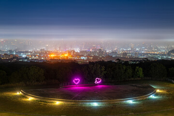 Wanggaoliao Night View Park at dusk features glowing heart sculptures overlooking the misty...