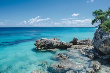 Fototapeta premium Vivid Turquoise Ocean And Rocky Coastline Under A Clear Blue Sky