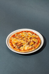 Close up view on Appetizing pizza cheese, corn, mushrooms and ham on gray background. Italian cuisine.