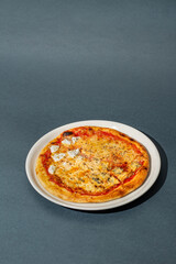 Four cheese pizza, homemade Italian pizza. Pizza on dark gray background. Traditional Italian cuisine. Place for text, top view.