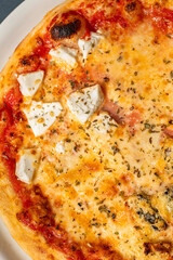 Four cheese pizza, homemade Italian pizza. Pizza on dark gray background. Traditional Italian cuisine. Place for text, top view.