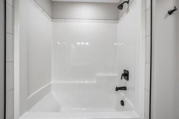 White bathroom with a black shower head and a white bathtub