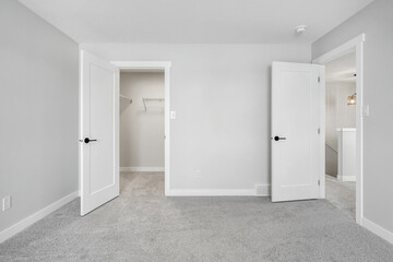 White bedroom with a white door and a white closet
