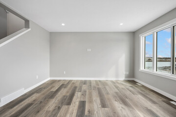 Large, empty living room with a view of the water