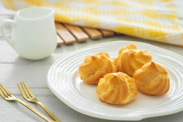 Cream puffs filled with vanilla custard cream on white plate