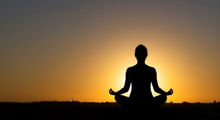 Silhouette of a person meditating in a yoga pose during sunrise, symbolizing inner peace, mindfulness, and spiritual balance in a calm natural setting.