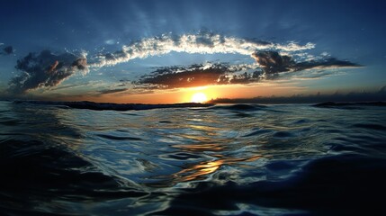 Naklejka premium A beautiful ocean sunset illuminates the water and cloudy sky