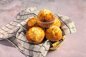 Fresh muffins in a basket on a checkered cloth