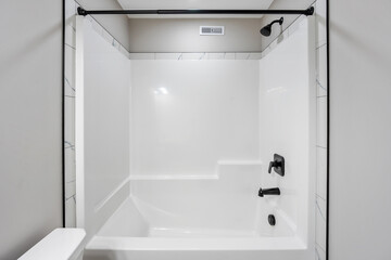 White bathroom with a black shower head and a white bathtub