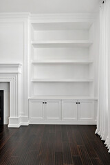 White room with a fireplace and a white bookcase