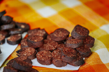 Close-up of blood sausages with grains in a coiled arrangement inside a woven basket, showcasing...