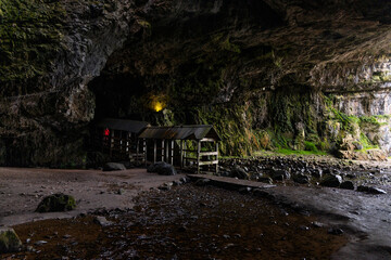 Smoo Cave in the Scottish Highlands captivates with its wide coastal opening and water-carved...