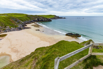 Panoramic viewpoint above Durness Beach, powerful waves crash against golden sand and striking rocks rise along the shore. A wild, breathtaking coastal scene in the heart of the Scottish Highlands.