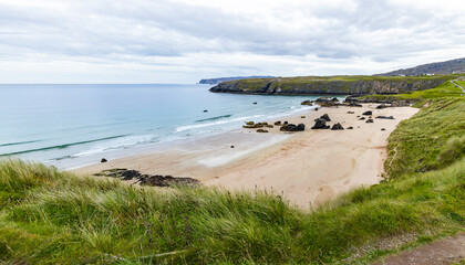Panoramic viewpoint above Durness Beach, powerful waves crash against golden sand and striking rocks rise along the shore. A wild, breathtaking coastal scene in the heart of the Scottish Highlands.
