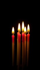 Several brightly colored birthday candles glow against a stark black backdrop, fire, happy