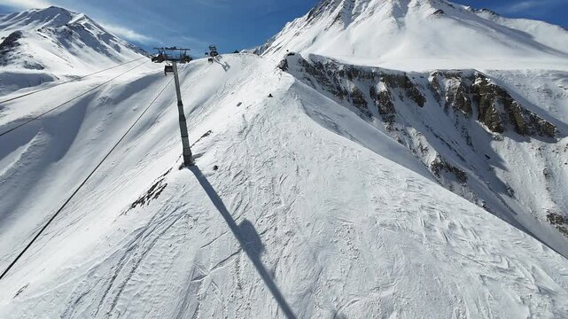 Ski resort Gudauri in Georgia. Cinematic FPV drone footage showcasing all the amenities of the resort, including snowboarders, gondolas, and chairlifts.