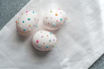 Brightly decorated easter eggs with colorful beads on a soft surface