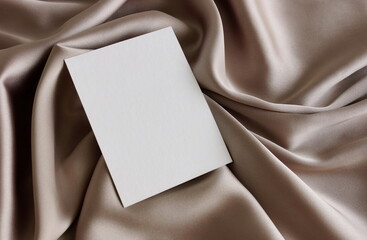 Card blank mockup close up on brown silk texture top view background with copy space. flatlay. Empty blank, greeting card mock up, template. 