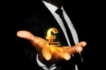 Black African businessman hand in suit and tie with 3D golden Pound sign symbol floating hovering in opened palm over black dark background