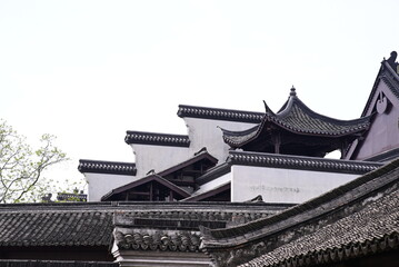 the dark tiled roofs and white walls of traditional Chinese architecture, emphasizing the intricate detailing and layered construction.