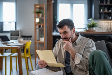 Focused entrepreneur reading important documents at home office