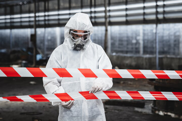 Workers in safety suits check chemicals in an old factory during a radiation emergency.