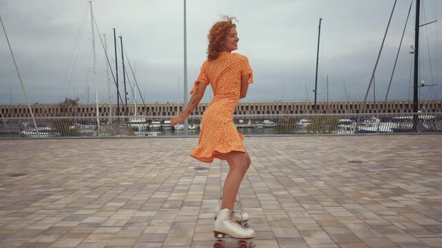 Happy young woman roller skating  and dancing outdoor in the city.