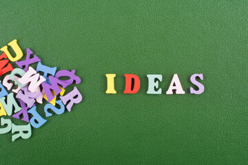 IDEAS word on green background composed from colorful abc alphabet block wooden letters, copy space for ad text. Learning english concept.