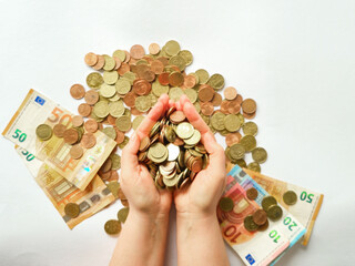 Hands Holding Various Euro Banknotes and Coins on a Clean White Background Surface