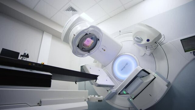 A radiation therapy machine is located in a state-of-the-art medical facility, ready for use in cancer treatment. The concept of advanced medical equipment in a professional clinical setting.