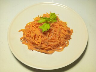 Korean-style carrot salad with fresh herbs on a white plate for healthy eating