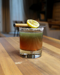 Charming glass of iced layered tea or herbal drink topped with cinnamon stick and lemon slice,...
