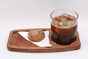 Charming rustic coffee scene displaying a glass of cold iced coffee filled with ice cubes, served...