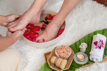 Woman indulges in blissful foot massage at luxurious spa salon while masseur give reflexology...