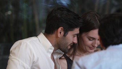 Portrait closeup smart man talking engaging in lively conversation with group friend or couple at dinner table in enjoy meeting special party at luxurious pub and restaurant at night time. Vinosity.