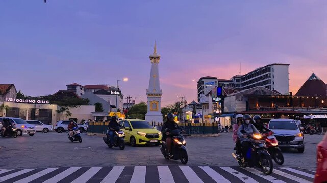Yogyakarta, Indonesia - April 19, 2025. Tugu Yogyakarta sunset in the afternoon with traffic. Tugu Jogja is one of the landmarks of Yogyakarta.