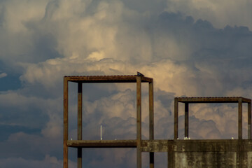 Abandoned industrial building in the city with cloudy sky background.