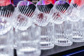 Row of elegant glass tumblers gleaming in a vibrant bar setting