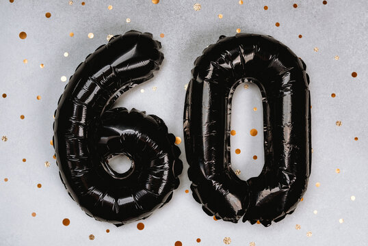 Celebrating a milestone birthday with black balloons and gold confetti backdrop