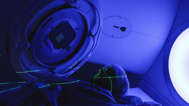 A young man undergoes radiation therapy for cancer at a state-of-the-art ocncology center. Concepcion of medical technology and theropy for cancer patients.