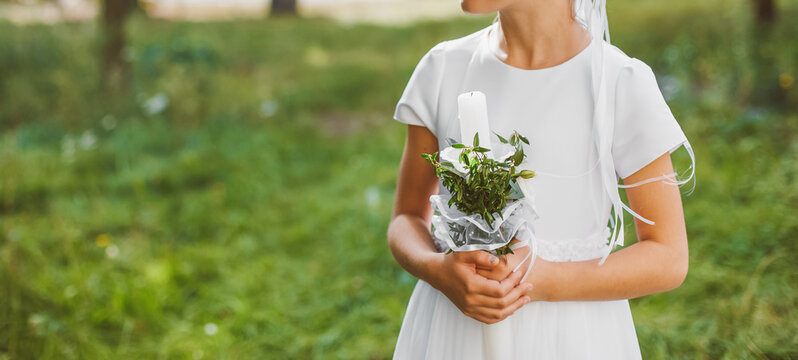 Young girl holding First Communion candle symbol of faith prayer and sacred Christian sacrament