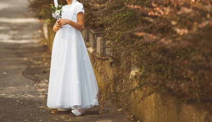 Young girl posing in white First Communion dress symbolizing purity faith and sacred Christian...