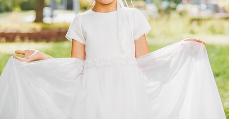 Young girl posing in white First Communion dress symbolizing purity faith and sacred Christian...