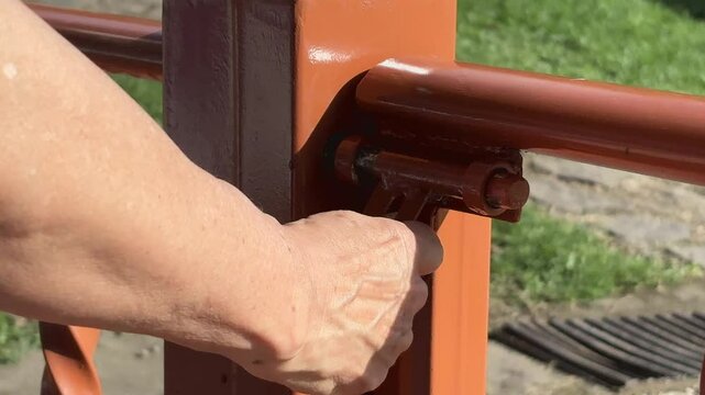Mano que cierra y abre cerradura de puerta de metal